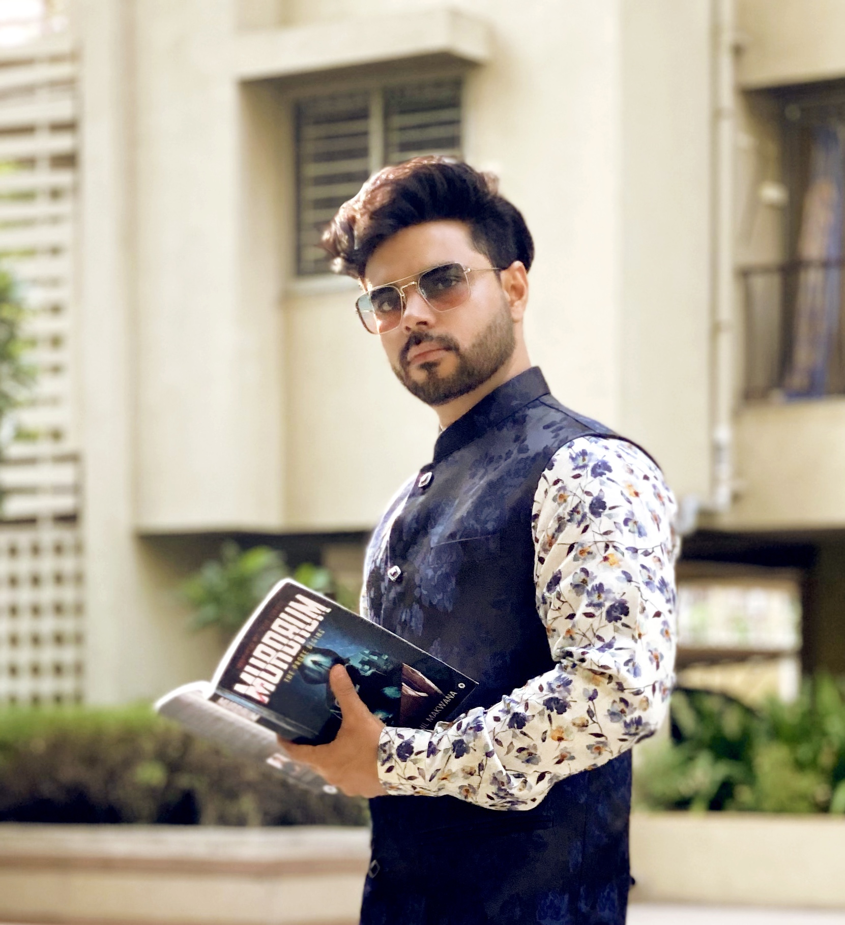 Dr.Sohil Makwana holding a book standing and posing